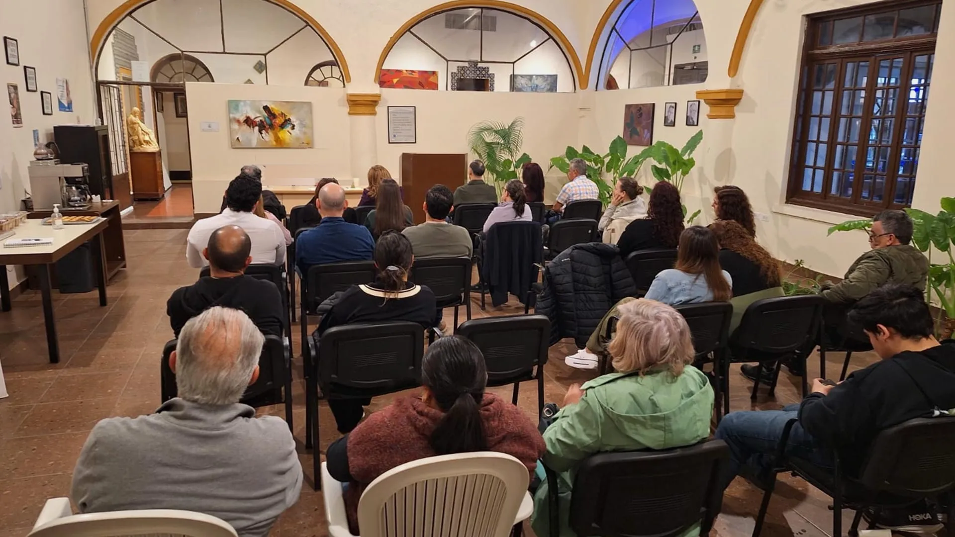 Familiares y residentes reunidos en una sesión en la sala principal de Lumenia