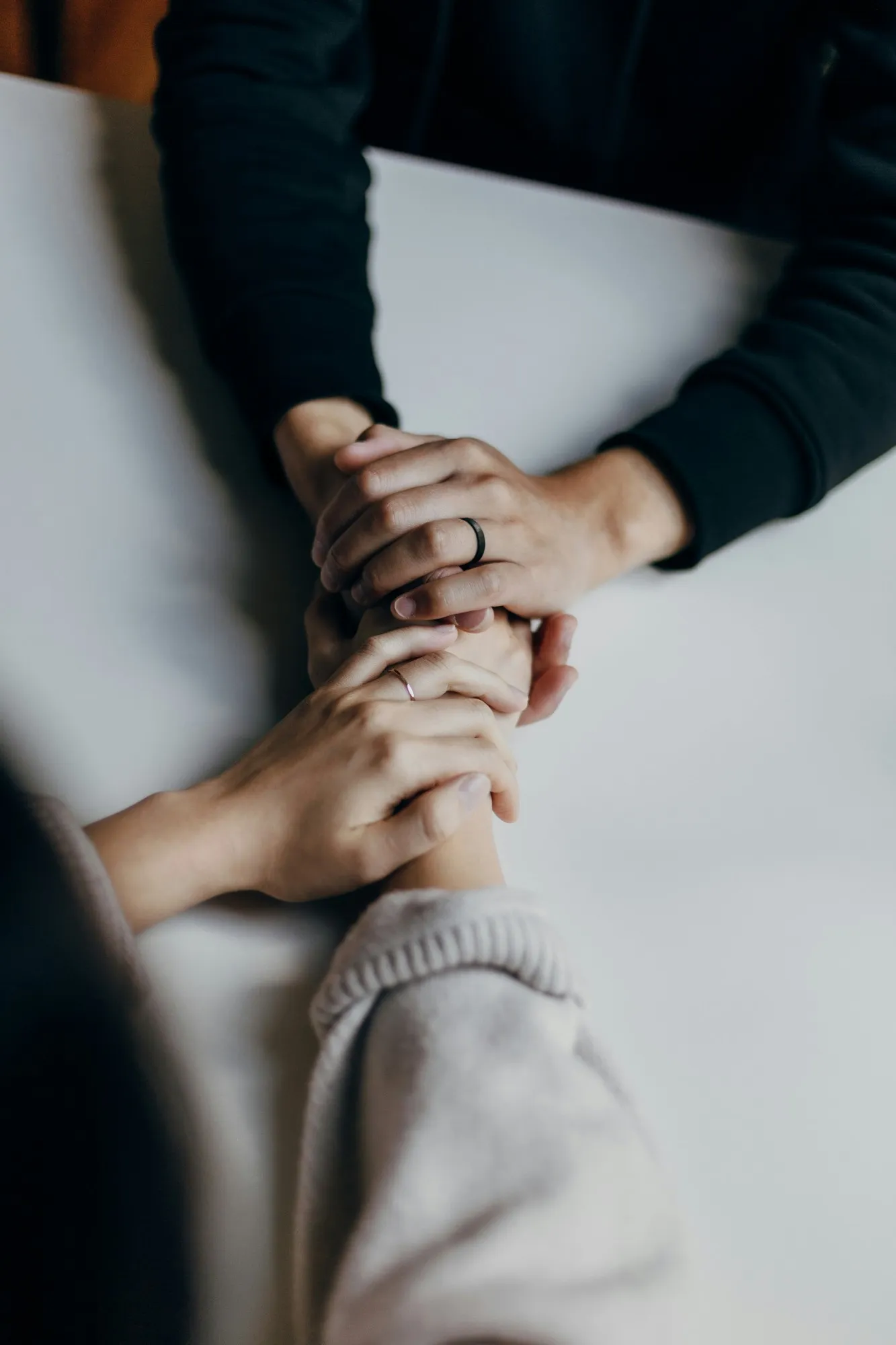 Dos personas se toman de las manos sobre una mesa en señal de apoyo