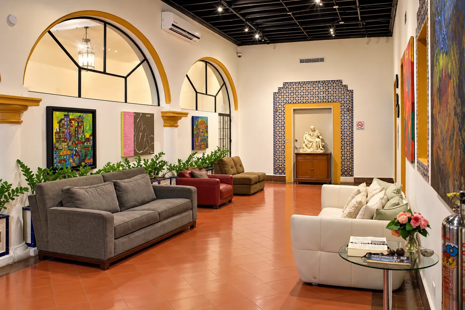 Pasillo principal con sillones, arcos y obras de arte